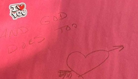 A Pink Piece Of Paper With A Sticker On It That Says, "I Love You," And Writing That Says, "and God Does Too" Along With A Heart, Underneath The Sticker.